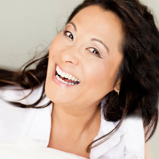 woman with a white shirt and black hair smiling